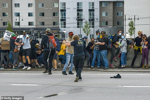 Police say Young was aiming at a Jeep that barreled into a crowd of protesters on a highway in Aurora on Saturday when he accidentally shot two demonstrators. A man can be seen pointing a gun down the highway in the photo above