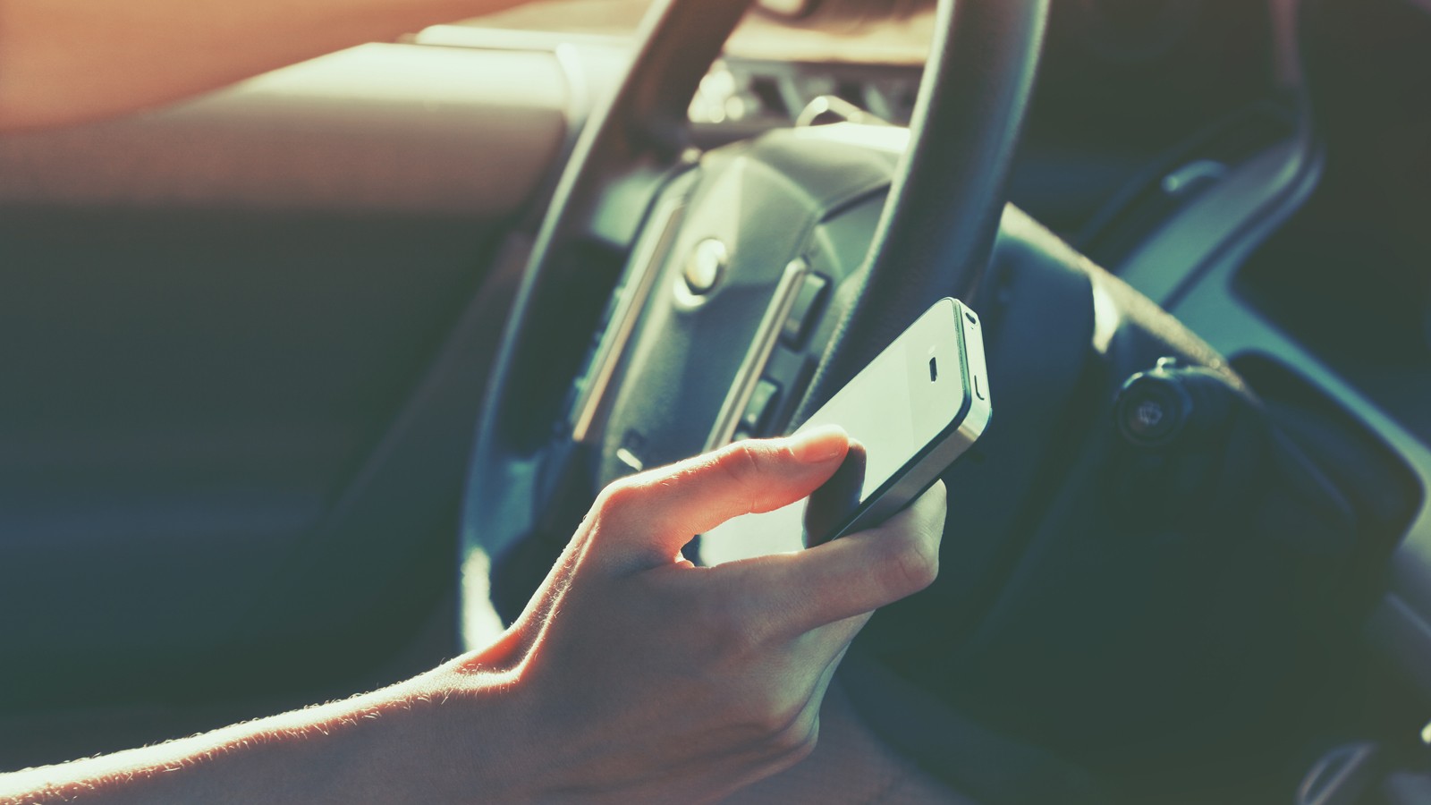 girls hand using smart phone while car driving